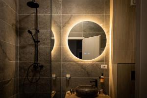 a bathroom with a shower with a sink and a mirror at Dan's Apartament in Seleuş +15 photos