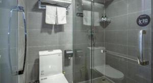 une salle de bain avec toilettes et douche en verre dans l'établissement City 118 Selected Hotel Xi'an Fengcheng Nan Road, à Xi'an 95 autres photos