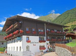 a building with flower boxes on the side of it at Gasthof Pension Rose in Virgen