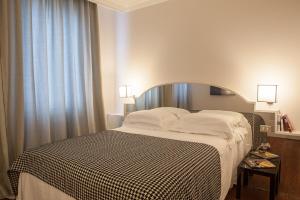 フィレンツェにあるVerdi Apartmentsのベッドルーム1室(ベッド1台、白黒の毛布付)