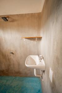 a bathroom with a sink on the wall at Mahue Rooms and Camping in Puerto Escondido