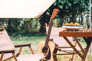 a guitar sitting on a chair next to a table at Qingyuan Zhilin Hot Spring Bed and Breakfast in Qingyuan