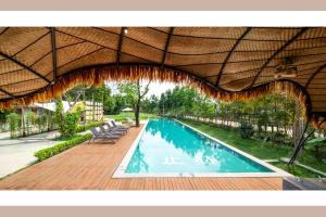 a swimming pool with a wooden deck and an umbrella at Qingyuan Zhilin Hot Spring Bed and Breakfast in Qingyuan