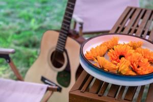 a bowl of flowers on a table next to a guitar at Qingyuan Zhilin Hot Spring Bed and Breakfast in Qingyuan