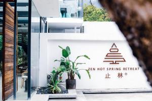 a sign for a tea hot spring retreat with a plant at Qingyuan Zhilin Hot Spring Bed and Breakfast in Qingyuan