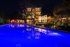 a swimming pool with blue lights in front of a house at Qingyuan Zhilin Hot Spring Bed and Breakfast in Qingyuan