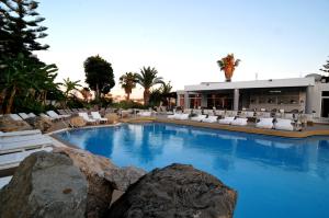 una piscina con tumbonas blancas y un complejo en Palm Beach Hotel - Adults only, en Cos