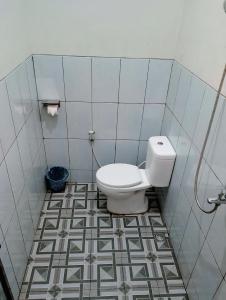 a bathroom with a toilet and a tile floor at Ikiikahomestay in Probolinggo +20 photos