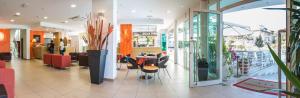 a lobby with a table and chairs in a building at Hotel San Francisco in Lignano Sabbiadoro