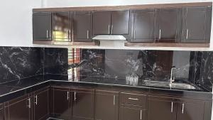 a kitchen with dark brown cabinets and a sink at Ocean Villa in Trincomalee