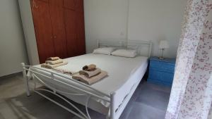 a bed with towels on it in a bedroom at Melistalia apartment 2 in Néa Michanióna