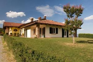 uma pequena casa branca com uma árvore no quintal em Eremo della Gasprina em La Morra
