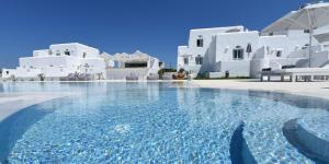 a swimming pool in front of white buildings at White Dunes Luxury Boutique Hotel in Santa Maria