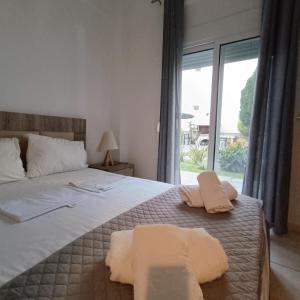 a bedroom with a large bed with towels on it at R&T Apartments in Kallithea Halkidikis