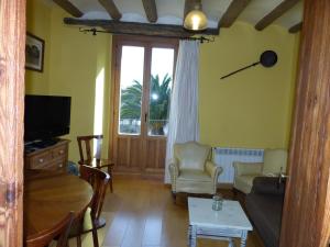 a living room with a couch and a tv at Casa Rural Iturrieta in Adiós