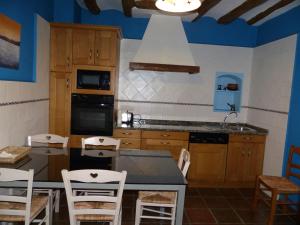 a kitchen with blue walls and a table and chairs at Casa Rural Iturrieta in Adiós