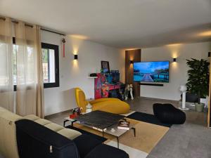 un salon avec un canapé et une télévision dans l'établissement sanary villa design piscine calme clim parking, à Sanary-sur-Mer