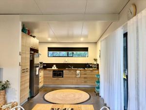 a kitchen with wooden cabinets and a large window at Panda's Patch Dunsborough in Dunsborough