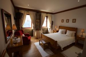 a bedroom with a bed and a red chair at Quinta de CasalMato in Resende