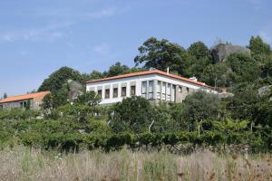 a white building on top of a hill at Quinta de CasalMato in Resende