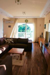 a living room with a couch and a table at Cezar Holiday Home in Sveti Stefan