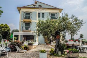 a building with a tree in front of it at Hotel Du Lac in Moniga