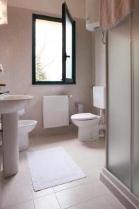 bagno con lavandino, servizi igienici e finestra di Residence Miravalle & Stella Alpina a Valdobbiadene