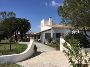 une maison blanche avec une clôture devant elle dans l'établissement Hotel Mas Des Barres, à Saintes-Maries-de-la-Mer