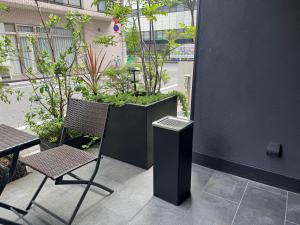 a chair and a trash can on a patio at HOTEL TABARD TOKYO in Tokyo