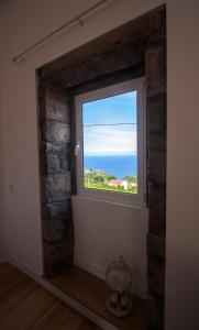 a window in a room with a view of the ocean at Casa do Simão in Nordeste