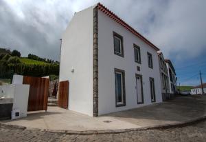 a white building with a door on the side of it at Casa do Simão in Nordeste