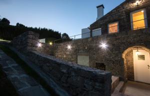 a stone house with lights on the side of it at Casa do Simão in Nordeste
