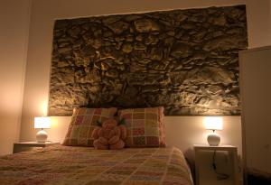 a bedroom with a large stone wall above a bed at Casa do Simão in Nordeste
