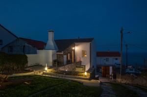 a house with lights on the side of it at night at Casa do Simão in Nordeste