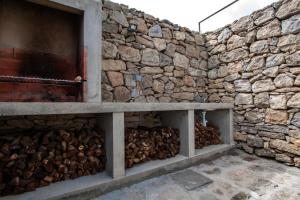 a stone wall with a pile of fire wood at Casa do Simão in Nordeste