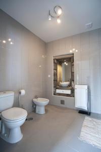 a bathroom with two toilets and a sink and a mirror at Casa do Simão in Nordeste +37 photos