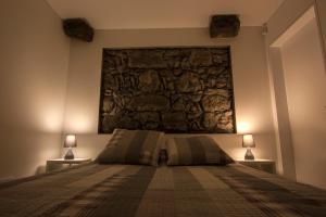 a bedroom with a large stone wall above a bed at Casa do Simão in Nordeste