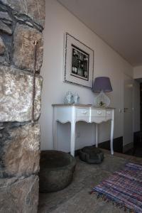 a room with a white desk and a stone wall at Casa do Simão in Nordeste