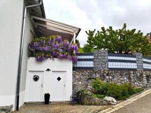a white garage with purple flowers on a wall at Fewo Haus Ema in Lahr