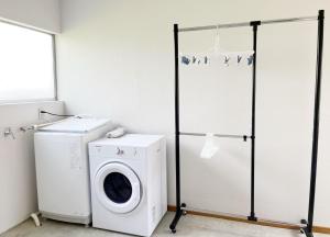 a laundry room with a washing machine and a washer at 竹の宿 2025年リノベ古民家 最大16名宿泊対応 湖まで徒歩4分 in Fujikawaguchiko