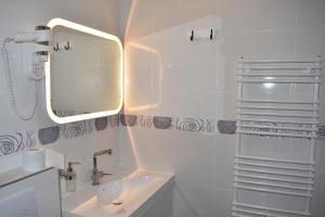 a white bathroom with a sink and a mirror at B&B Cool Centre Zagreb in Zagreb