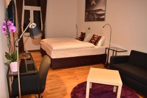 Habitación pequeña con cama y sofá en B&B Cool Centre Zagreb, en Zagreb