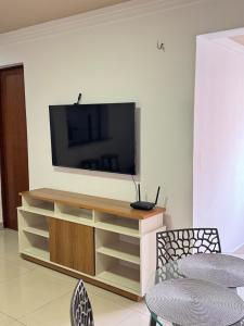 a living room with a entertainment center with a flat screen tv at Apê 003 in São Luís +5 photos