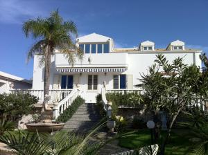 una casa blanca con una palmera y escaleras en Villa Sissi, en Cava dʼAliga