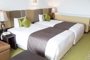 Кровать или кровати в номере Royal View Hotel Churaumi