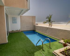 a swimming pool with the beach in the background at Luxury Villa Beach Front in Salalah +6 photos