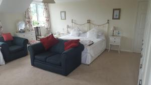 a bedroom with a bed and a couch and a chair at Monks Cleeve in Exford