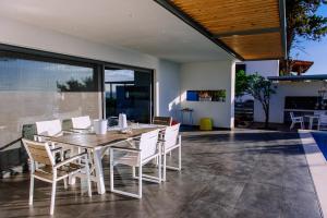 a dining room with a wooden table and white chairs at Villa Titi in Kamínia