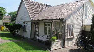 una pequeña casa gris con un techo inclinado en Smilčių namelis, en Palanga
