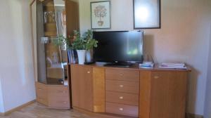 a tv on a wooden dresser with a dresser at Smilčių namelis in Palanga